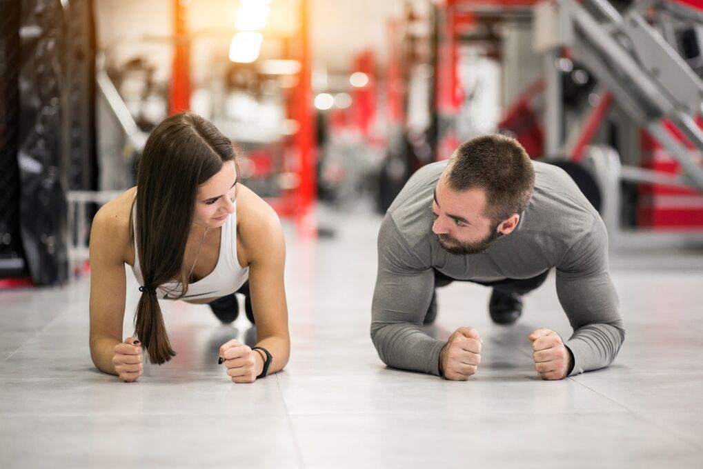 Un uomo e una donna eseguono l'esercizio Plank, pensato per tutti i gruppi muscolari
