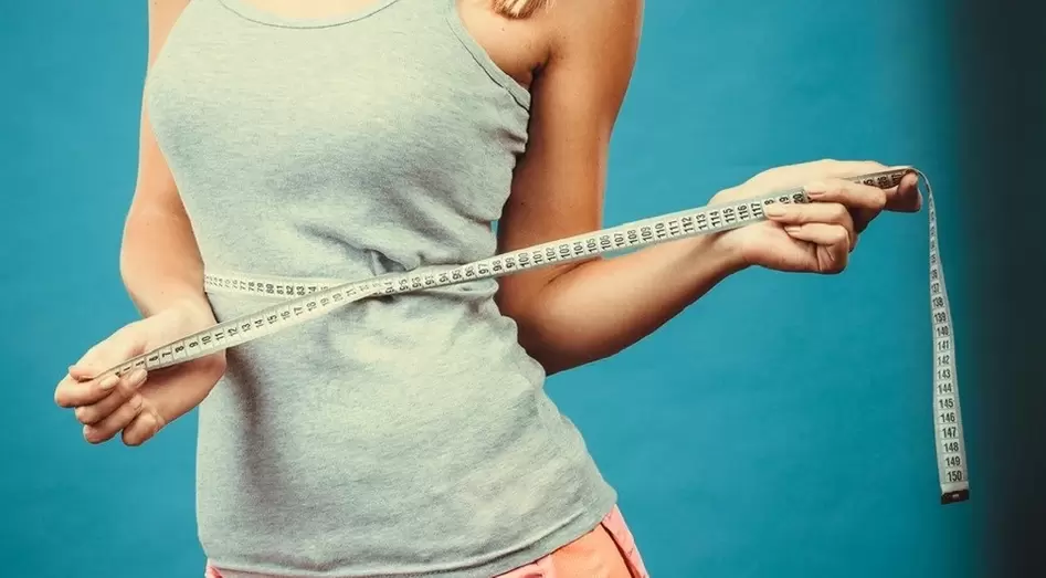La ragazza snella risolve i risultati della perdita di peso in una settimana
